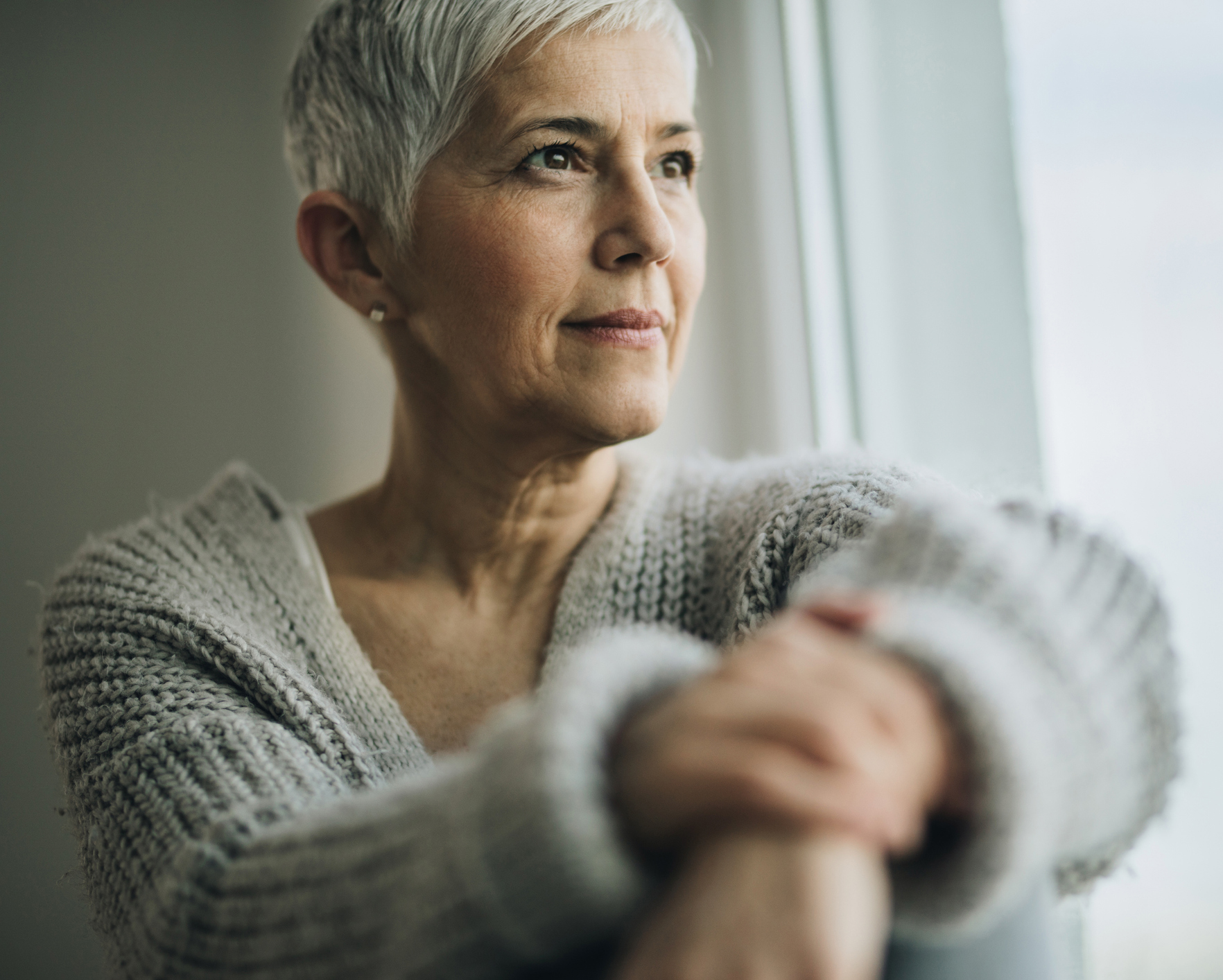 Portrait of beautiful mature woman relaxing by the window. Anterior Cervicoplasty in Philadelphia, PA
